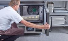 chef putting tray of food in a blast chiller