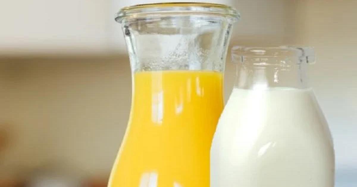 glass container of orange juice and glass bottle of milk